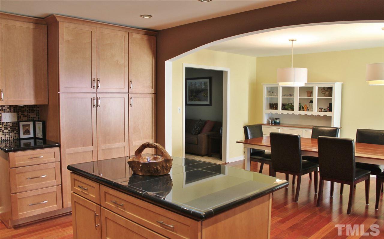 4004 Grimstead Lane Raleigh, NC 27613 - Photo 6 of 25 a kitchen with granite countertop a stove a sink and a dining table