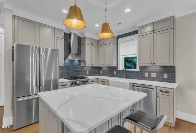 a kitchen with stainless steel appliances a stove a refrigerator and a sink