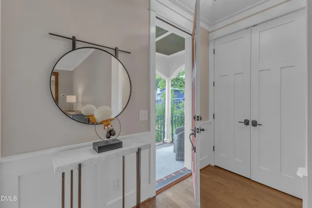 a view of a room with a mirror and hardwood floor
