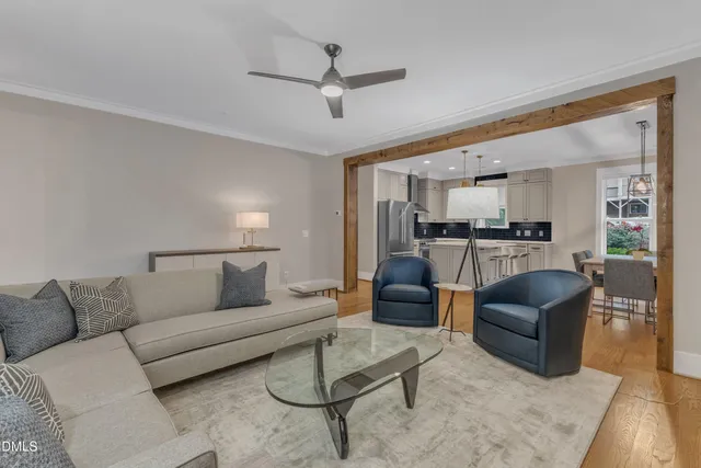 a living room with furniture and a view of kitchen