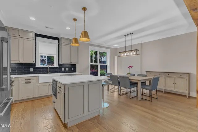 a kitchen with a table chairs stove and wooden floor