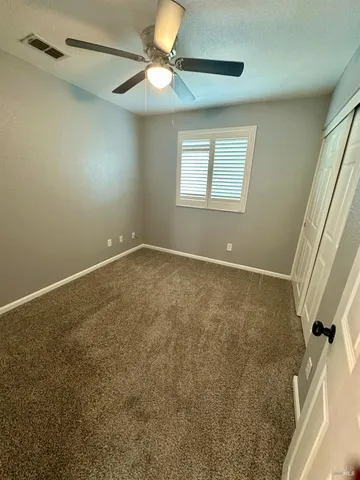 en empty room with windows and fan