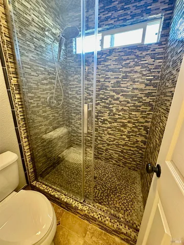 a bathroom with a toilet and a shower