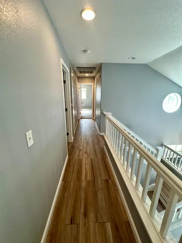 a view of a hallway with wooden floor