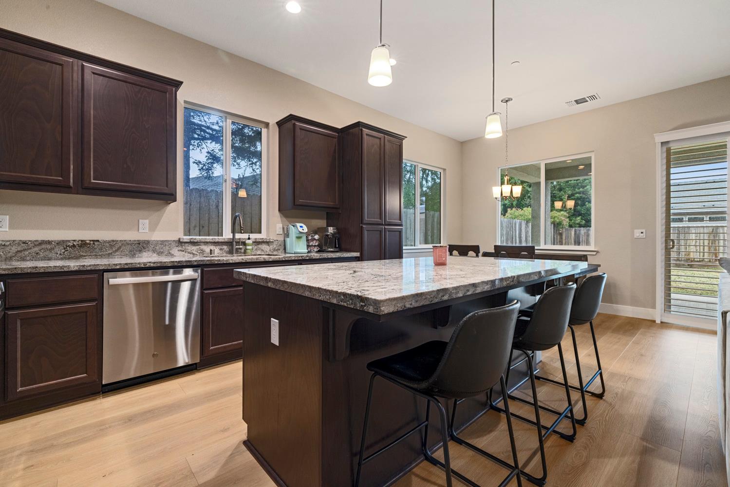 3700 Colorado Avenue Turlock, CA 95382 - Photo 12 of 46 a kitchen with stainless steel appliances granite countertop wooden floors a stove a sink and a refrigerator