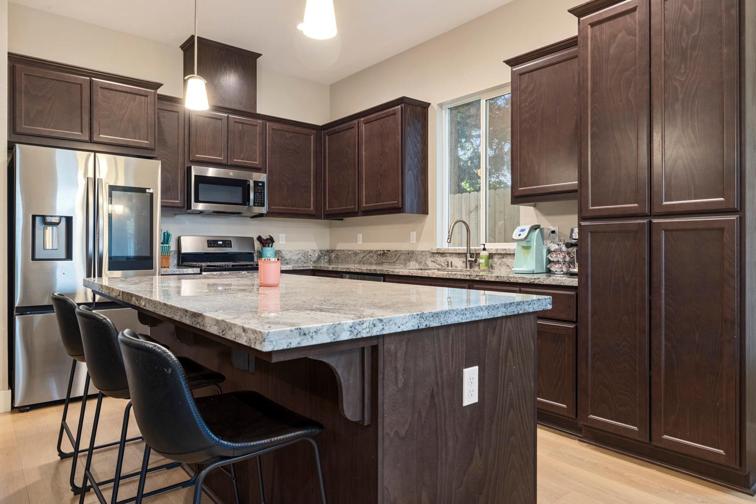 3700 Colorado Avenue Turlock, CA 95382 - Photo 13 of 46 a kitchen with stainless steel appliances granite countertop a sink refrigerator and microwave