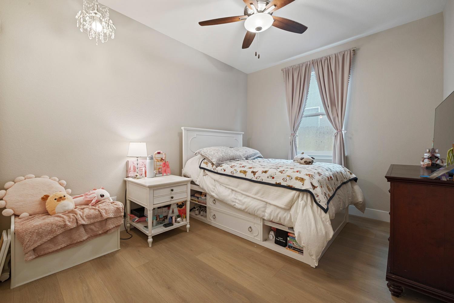 3700 Colorado Avenue Turlock, CA 95382 - Photo 30 of 46 a bedroom with a bed and a chandelier