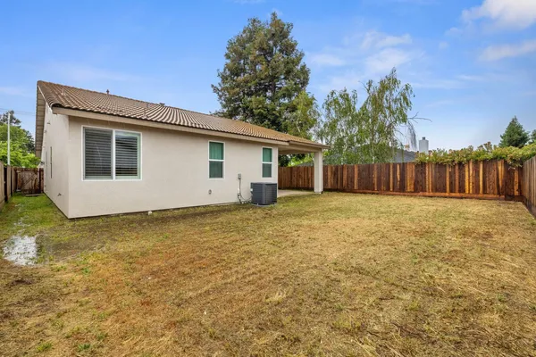 a view of backyard with a tub and wooden fence