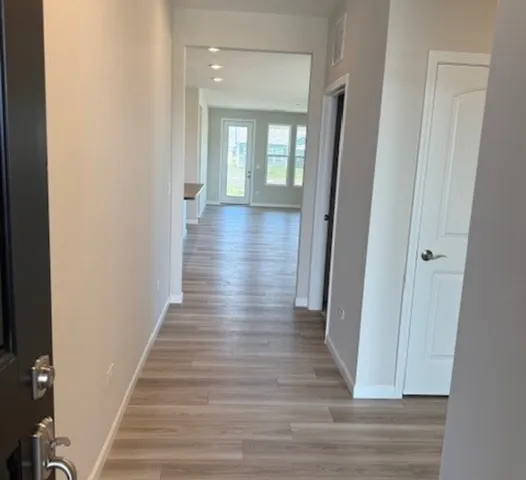 a view of a hallway with wooden floor and staircase