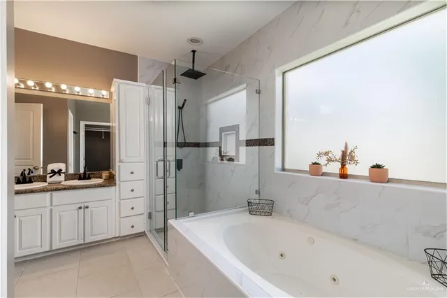 a bathroom with a bathtub a double vanity sink and mirror