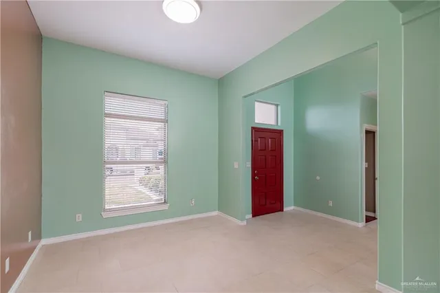 a view of an empty room with window and stairs
