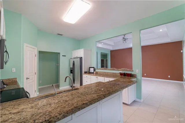 a bathroom with a granite countertop sink and a large mirror