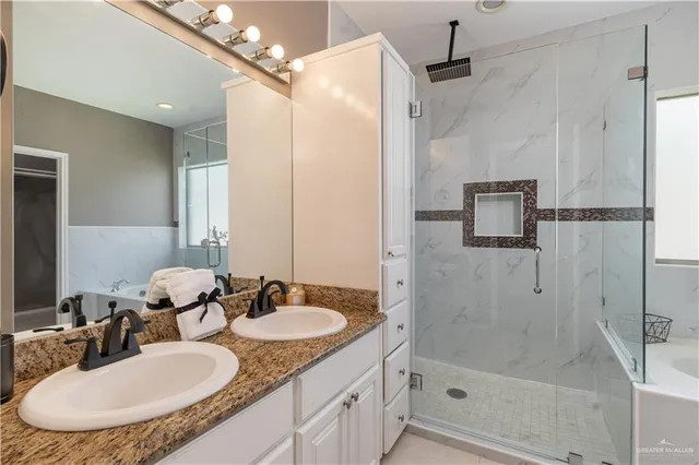 a bathroom with a granite countertop sink a mirror a shower and a mirror