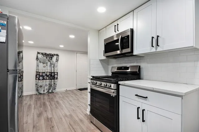 a kitchen with stainless steel appliances granite countertop a stove a microwave and a refrigerator