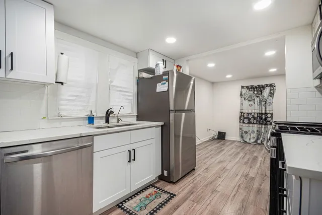 a kitchen with stainless steel appliances a refrigerator sink and cabinets