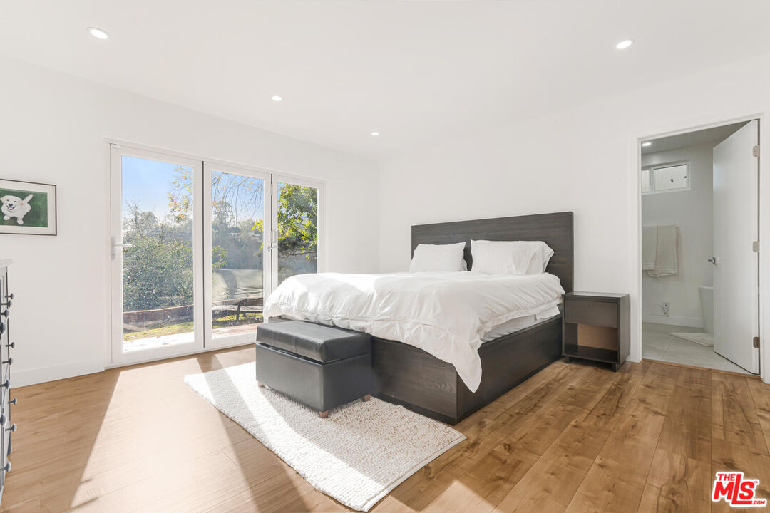 2204 Ridgemont Drive Los Angeles, CA 90046 - Photo 22 of 34 a bedroom with a large bed and a large window