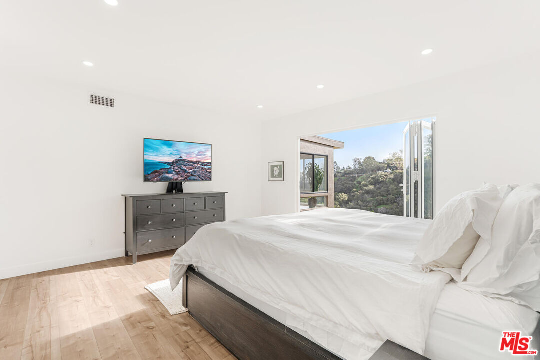 2204 Ridgemont Drive Los Angeles, CA 90046 - Photo 23 of 34 a bedroom with a bed and a large window