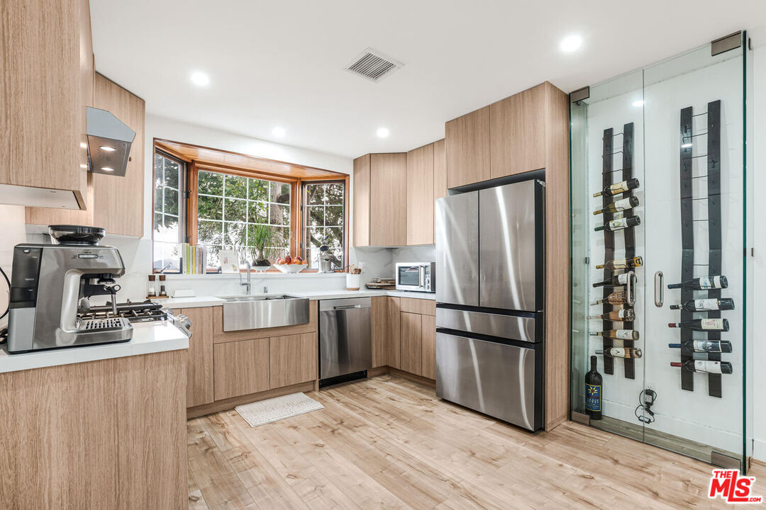 2204 Ridgemont Drive Los Angeles, CA 90046 - Photo 6 of 34 a kitchen with granite countertop stainless steel appliances a refrigerator cabinets and wooden floor