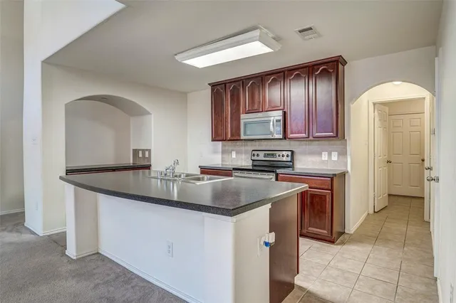 a kitchen with stainless steel appliances granite countertop a sink stove and cabinets