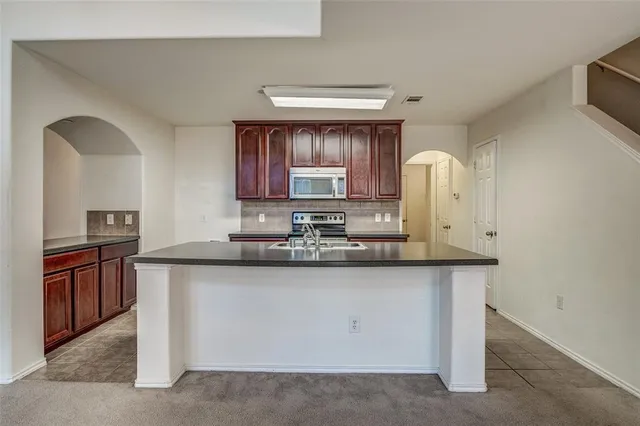 a kitchen with stainless steel appliances granite countertop a sink stove and cabinets