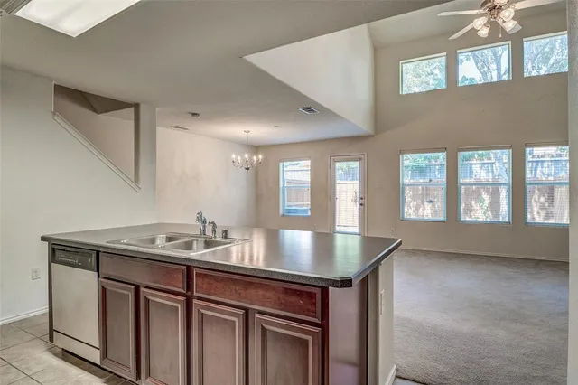 a dining hall with stainless steel appliances granite countertop a sink and a large window