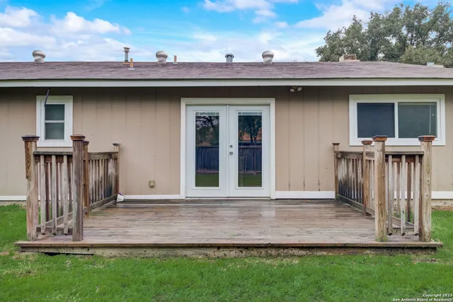 a view of a house with a small yard and a large tree