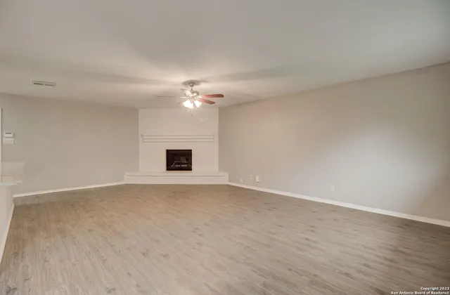 a view of an empty room with a chandelier fan