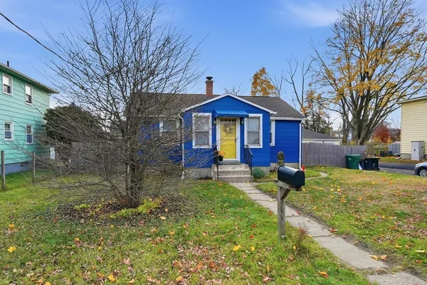a view of a yard in front of a brick house with large windows
