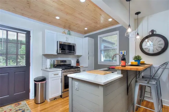 a open kitchen with a stove a sink dishwasher and a microwave oven with cabinets
