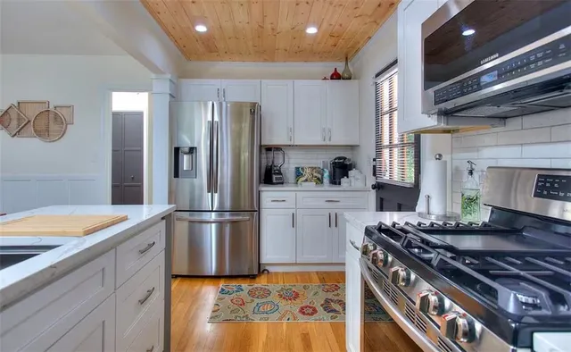 a kitchen with stainless steel appliances granite countertop a stove and a refrigerator