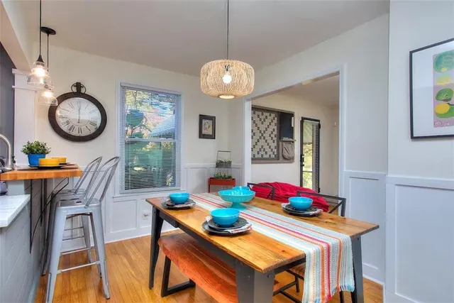 a view of a dining room with furniture clock and wooden floor