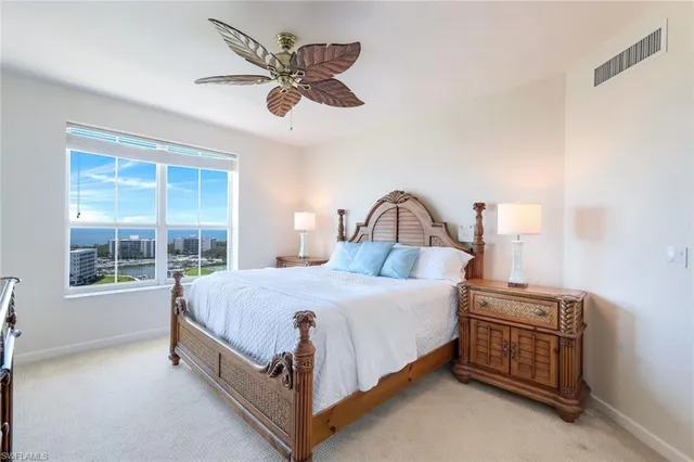 a bedroom with a bed chandelier and a window