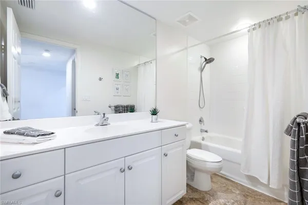 a bathroom with a sink toilet vanity and tub