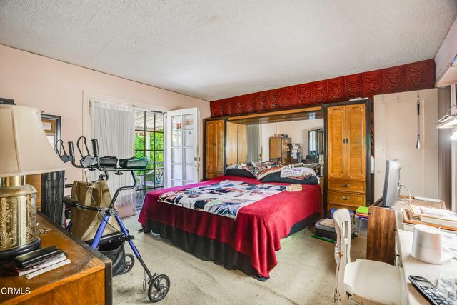 a bedroom with bed and large windows
