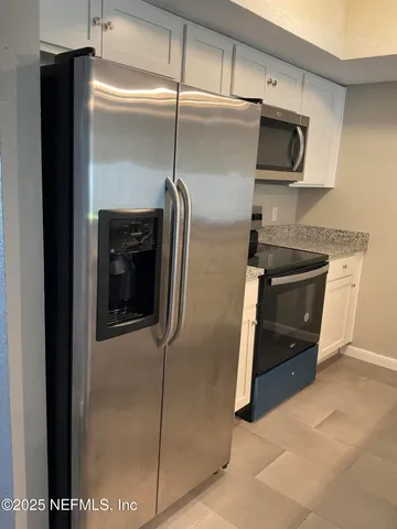 a kitchen with a refrigerator and a microwave