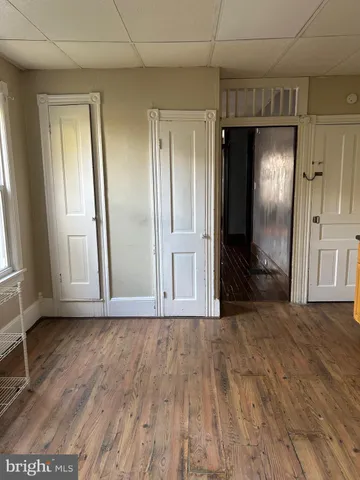 a view of empty room with wooden floor and window