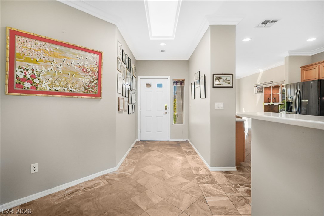 2738 Grand Forks Road Henderson, NV 89052 - Photo 6 of 52 An inviting entrance foyer welcomes guests with elegant crown molding and classic tile flooring.