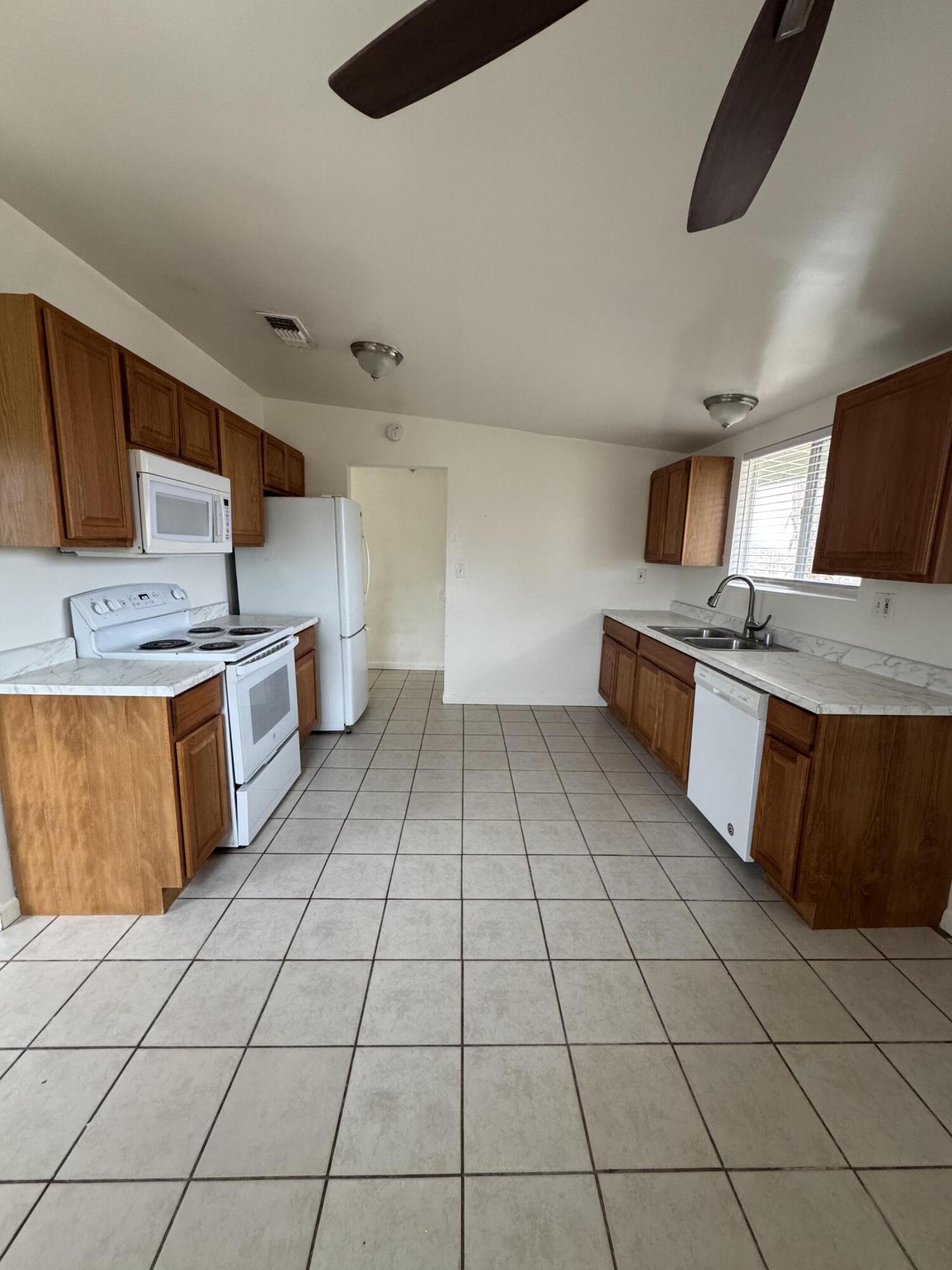 5958 El Reposo Street Joshua Tree, CA 92252 - Photo 15 of 30 a kitchen with stainless steel appliances a sink a stove top oven a counter space and cabinets