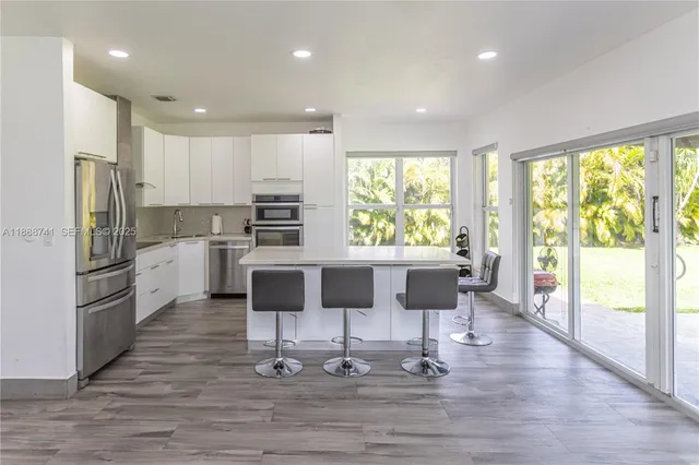 a kitchen that has a sink a stove top oven a counter space and a couch