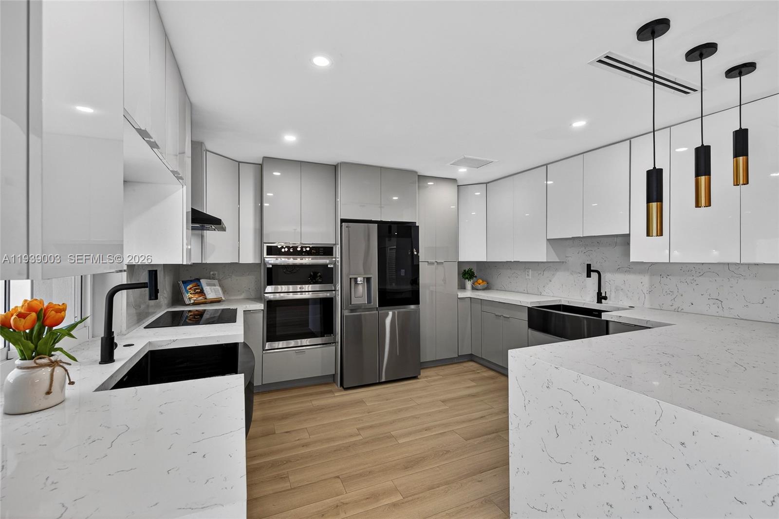 4712 Cleveland Street Hollywood, FL 33021 - Photo 17 of 49 a kitchen with refrigerator a microwave a stove and chairs with wooden floor