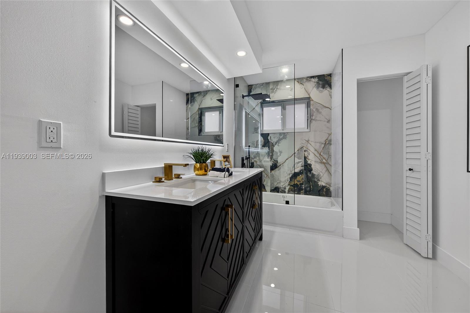 4712 Cleveland Street Hollywood, FL 33021 - Photo 29 of 49 a bathroom with a sink and mirror