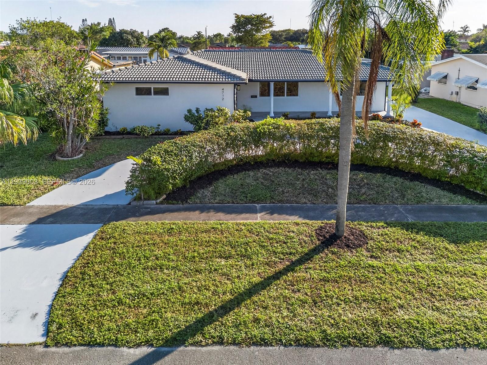 4712 Cleveland Street Hollywood, FL 33021 - Photo 3 of 49 a front view of a house with garden