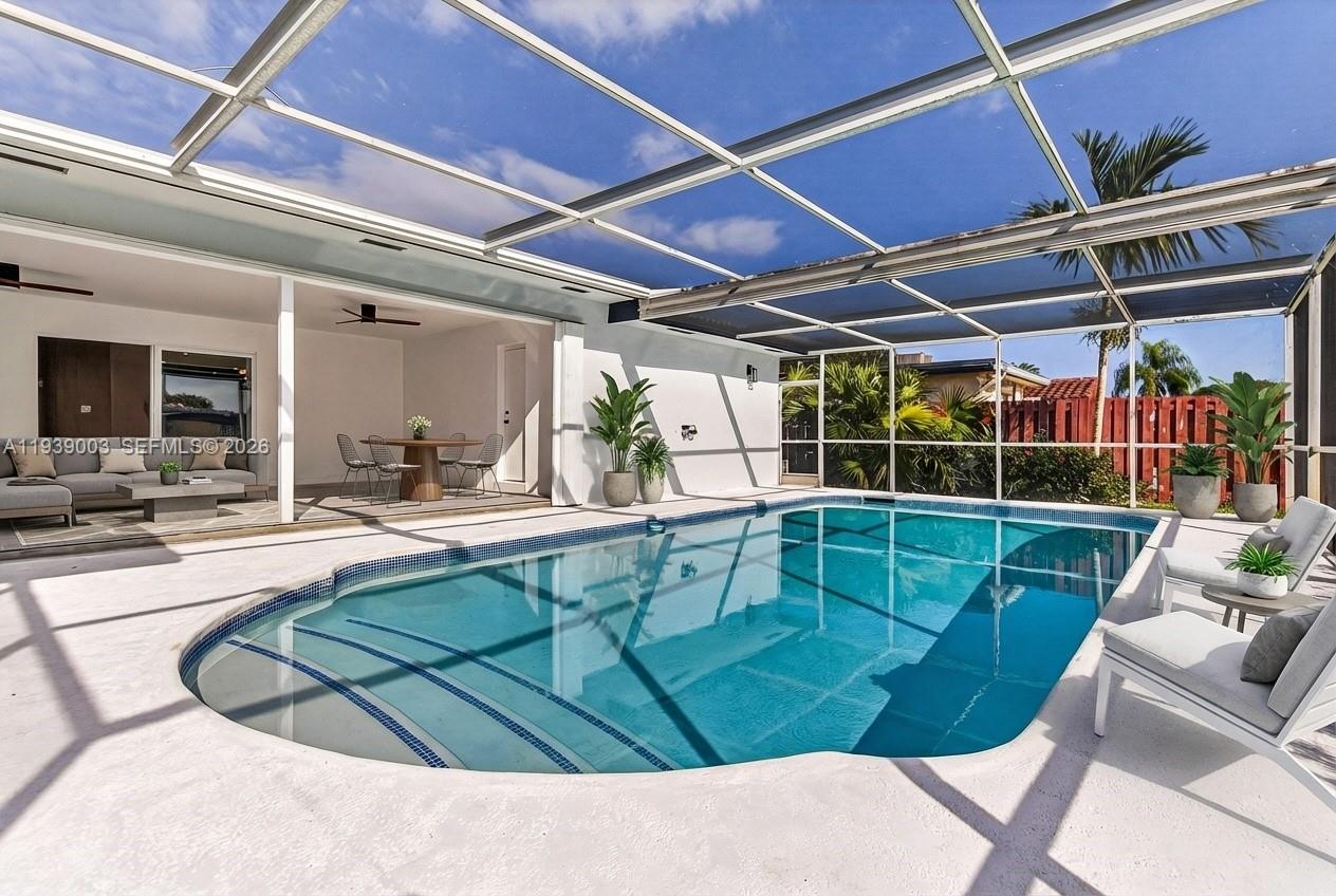 4712 Cleveland Street Hollywood, FL 33021 - Photo 36 of 49 a view of a swimming pool with a couches chairs and potted plants