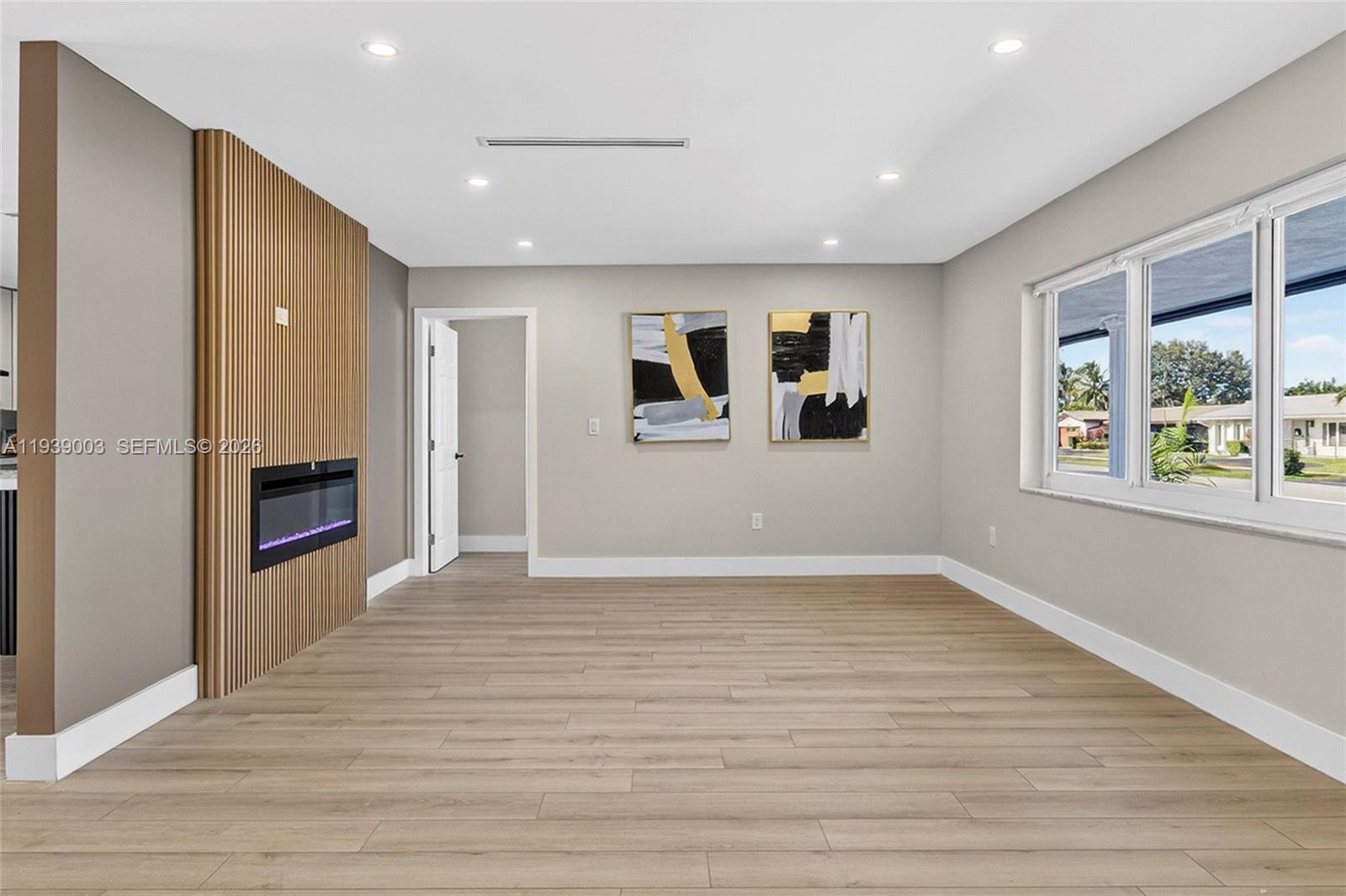 4712 Cleveland Street Hollywood, FL 33021 - Photo 5 of 49 a view of an empty room with wooden floor and a window