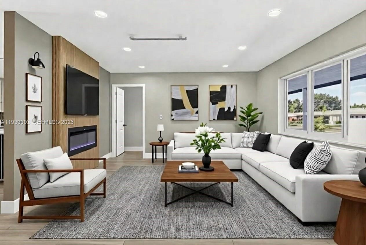 4712 Cleveland Street Hollywood, FL 33021 - Photo 6 of 49 a living room with furniture a flat screen tv and a fireplace