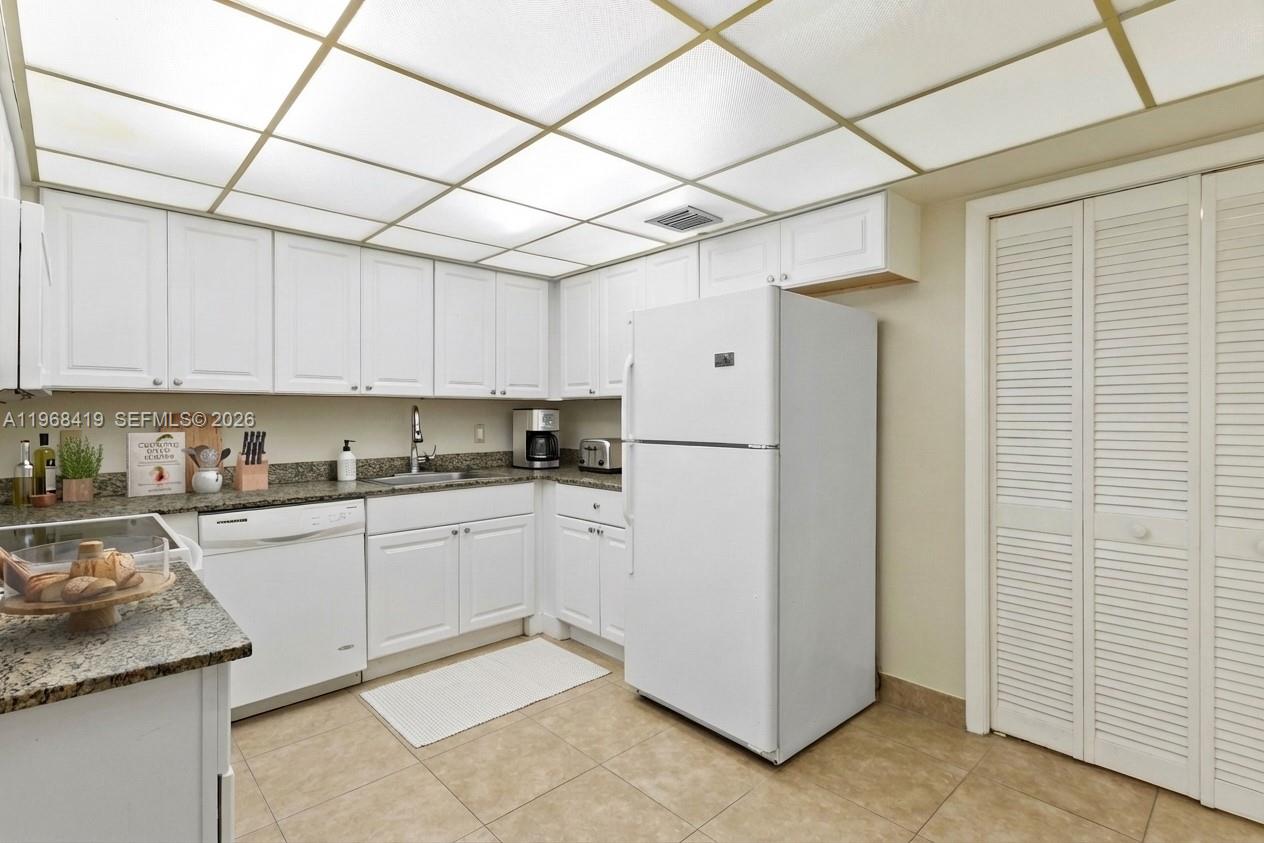 16400 Golf Club Road, Unit 104 Weston, FL 33326 - Photo 12 of 24 a kitchen with cabinets and stainless steel appliances