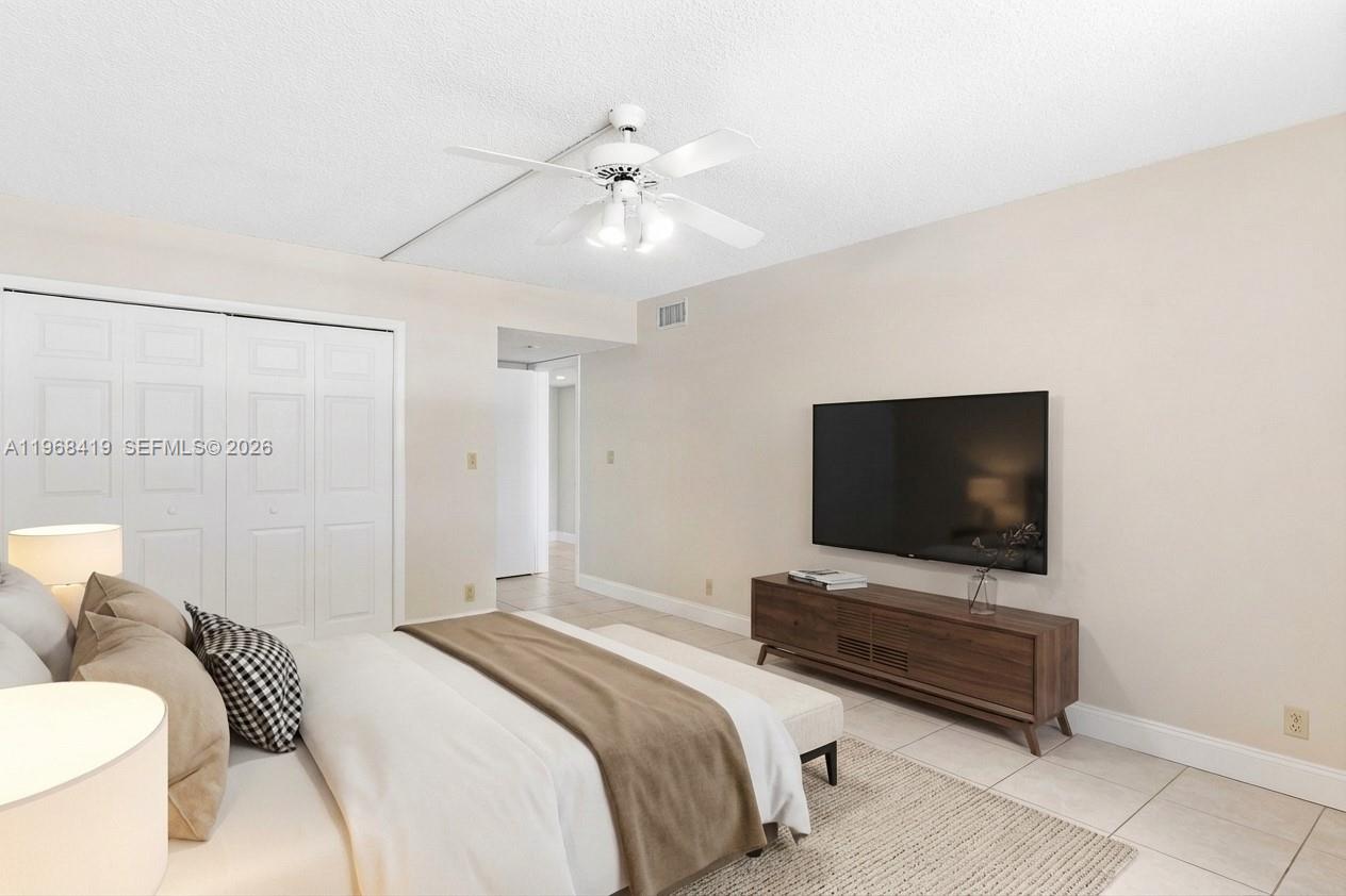 16400 Golf Club Road, Unit 104 Weston, FL 33326 - Photo 16 of 24 a bedroom with a bed and a flat screen tv