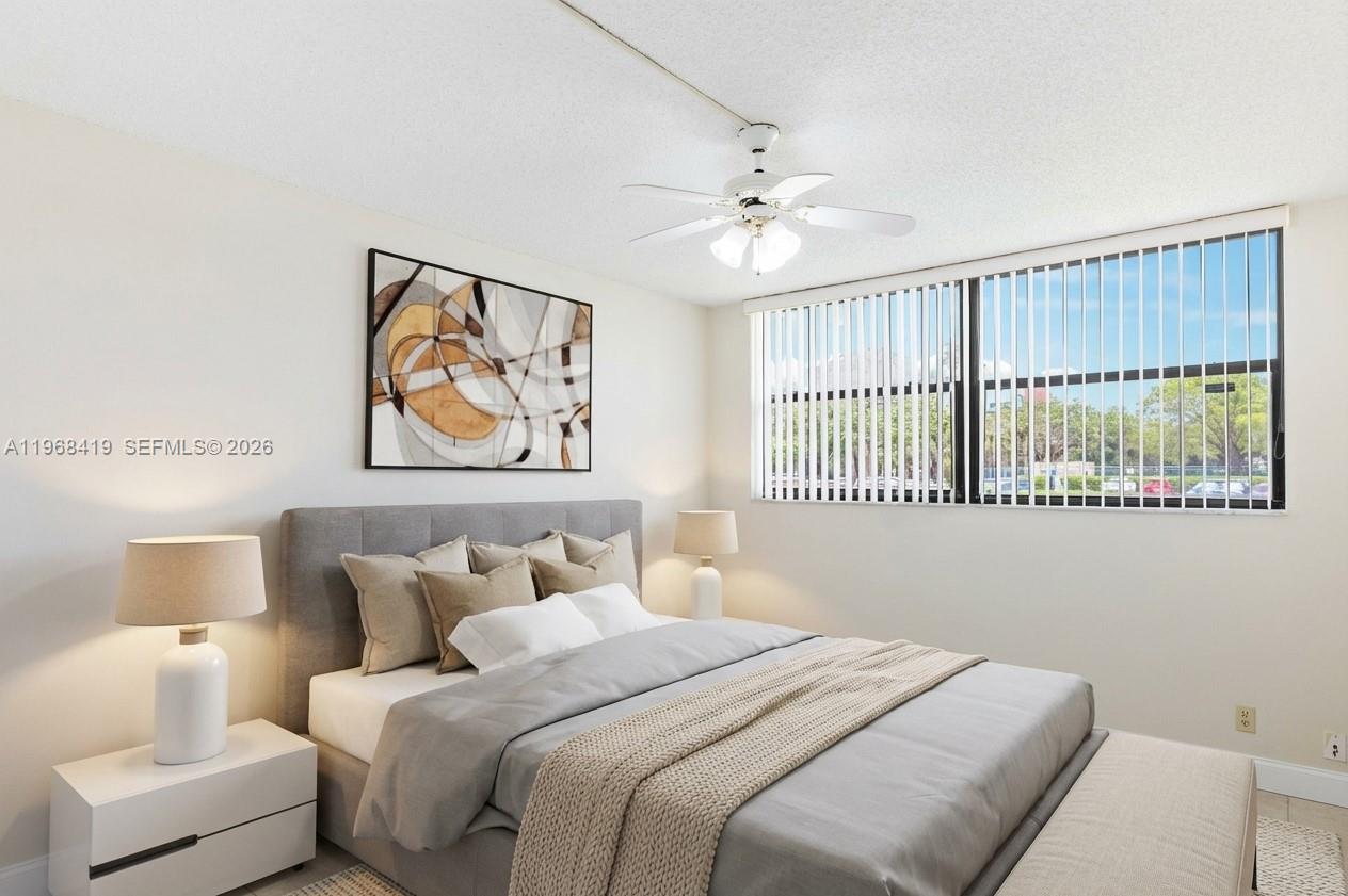 16400 Golf Club Road, Unit 104 Weston, FL 33326 - Photo 20 of 24 a bedroom with a bed and a painting on the wall