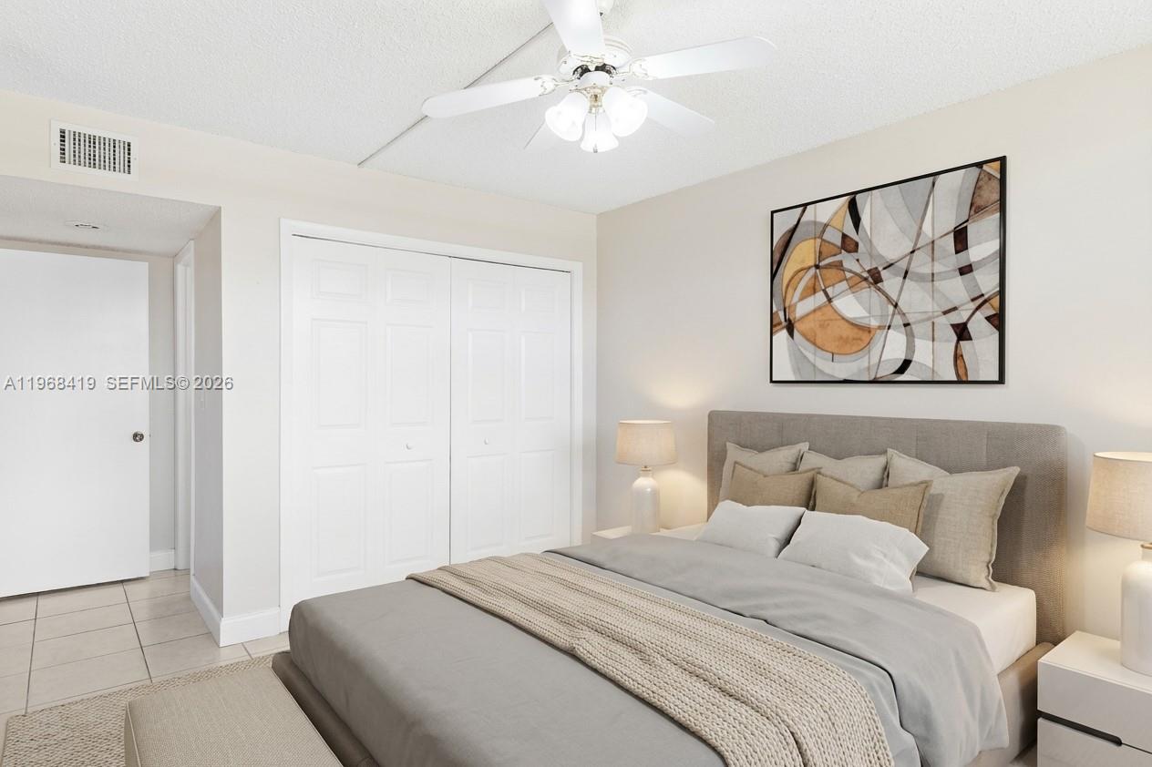 16400 Golf Club Road, Unit 104 Weston, FL 33326 - Photo 21 of 24 a bedroom with a bed and a painting on the wall
