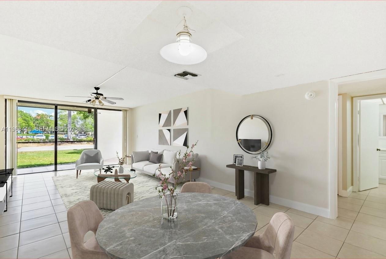 16400 Golf Club Road, Unit 104 Weston, FL 33326 - Photo 7 of 24 a living room with furniture a large window and a chandelier